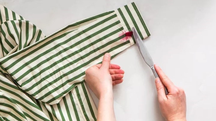 مرحله اول پاک کردن لکه لبو از لباس؛ برداشتن تکه لبو با چاقو کند