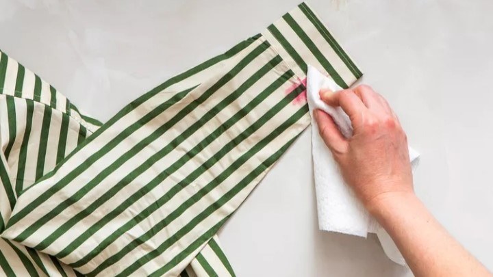 مرحله دوم پاک کردن لکه لبو از لباس؛ ضربه زدن با دستمال