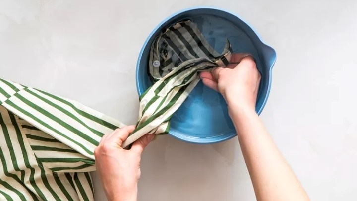 مرحله ششم پاک کردن لکه لبو از لباس؛ آبکشی با آب سرد